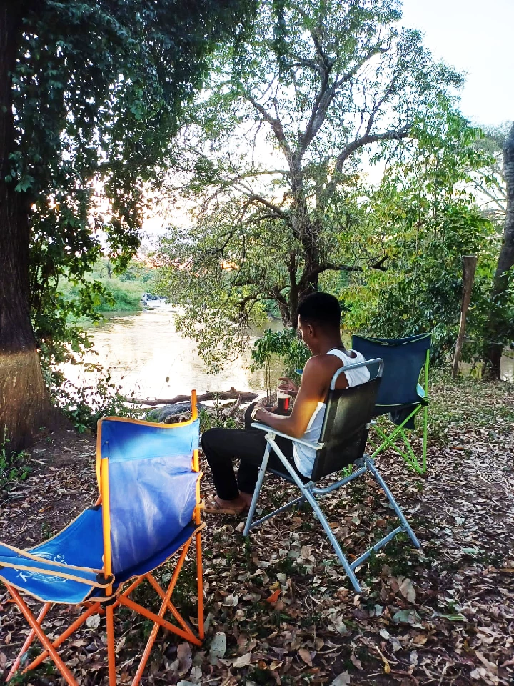 Outdoor riverside seating at camp